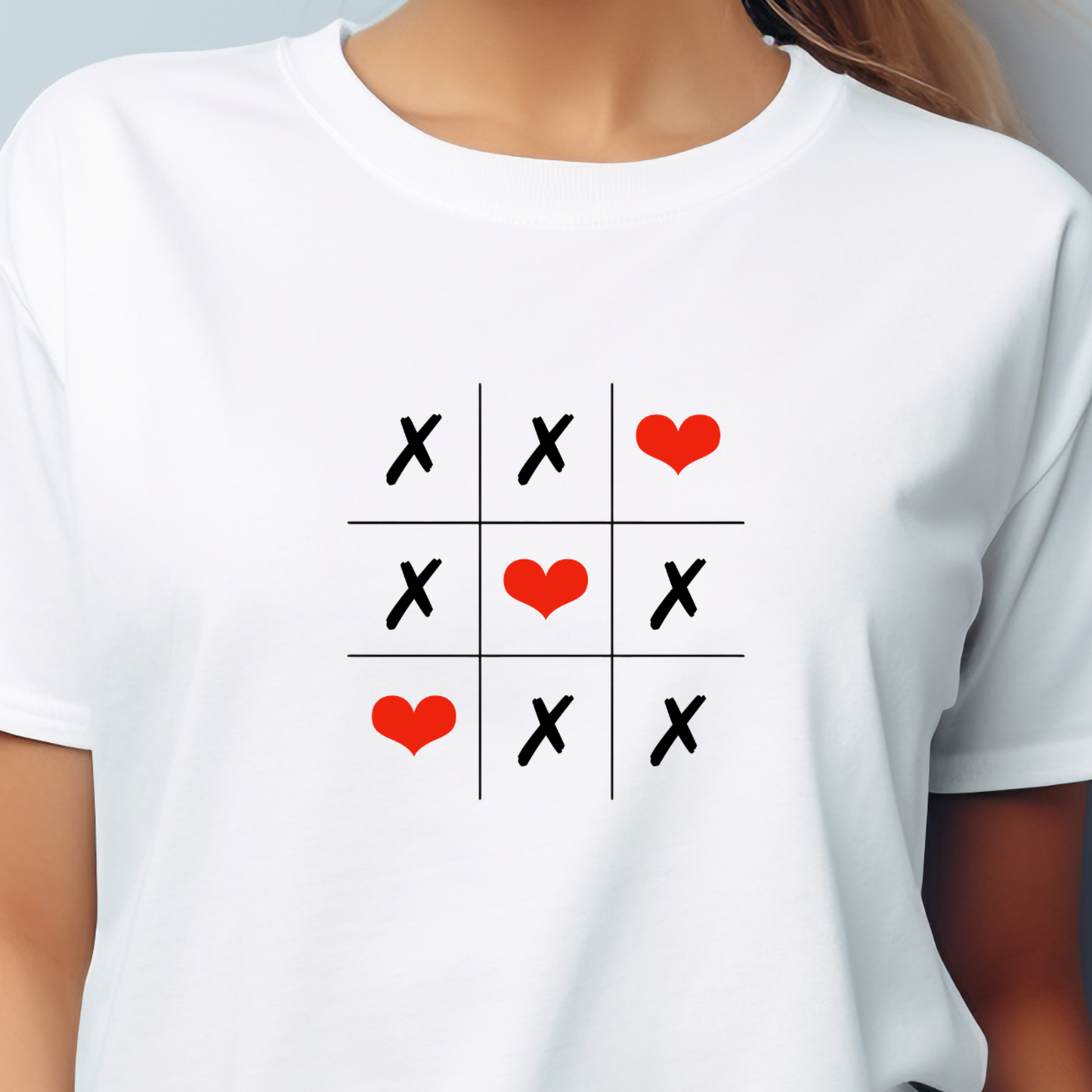 Moteriški marškinėliai "Love Game" - balti moteriški marškinėliai su kryžiukų ir nuliukų žaidimu, kuriame vietoj nuliukų pavaizduotos raudonos širdelės, sukuriantys žaismingą ir romantišką dizainą