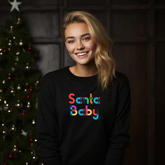 Juodas moteriškas džemperis su spalvingu užrašu "Santa Baby" prie kalėdinės eglutės. Stilingas ir linksmas dizainas sukuria šventinę nuotaiką. Moteriškas džemperis "Santa Baby" Black - puikus pasirinkimas šventėms. Moteriški džemperiai, Perkamiausi džemperiai, Naujausi dizainai, Kalėdinių džemperių kolekcija