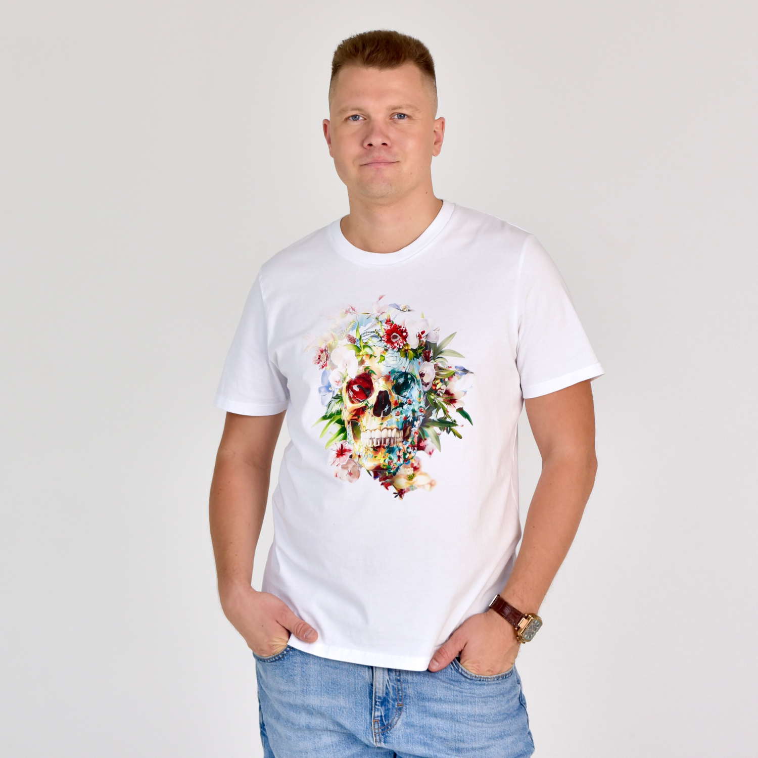 Stilingi balti marškinėliai su spalvingu gėlių kaukolės dizainu, atspindinčiu gyvybės ir mirties harmoniją. Unikalus Designedbyme.lt kūrinys, tobula dovana ieškančiam išskirtinumo. Vyriški marškinėliai, Vasaros kolekcija, Naujausi dizainai