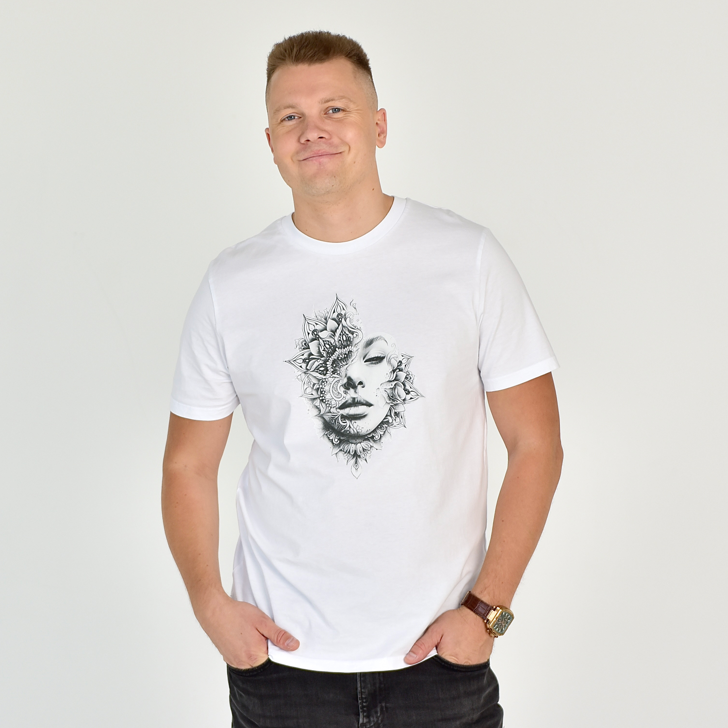 Vyras dėvi baltą "Tattoo Head" marškinėlius su menišku tatuiruočių įkvėptu dizainu, idealiai tinkančius stilingam gyvenimo būdui. Marškinėliai “Designedbyme.lt” puikiai tinka tiek kasdienai, tiek ypatingoms progoms. Vyriški marškinėliai,Visi produktai, Vasaros kolekcija 
