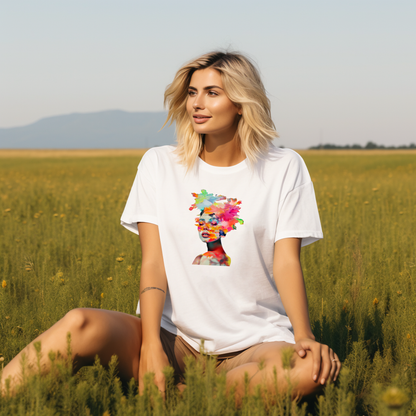 Moteris su stilingais "Spring Girl" marškinėliais, puošti spalvingu moters veido atvaizdu, sėdi saulėtame lauke. Unikalus Designedbyme.lt dizainas atspindi pavasario gyvybingumą ir jaunatvišką dvasią, Moteriški marškinėliai, Vasaros kolekcija , BESTSELLER'iai , Naujausi dizainai