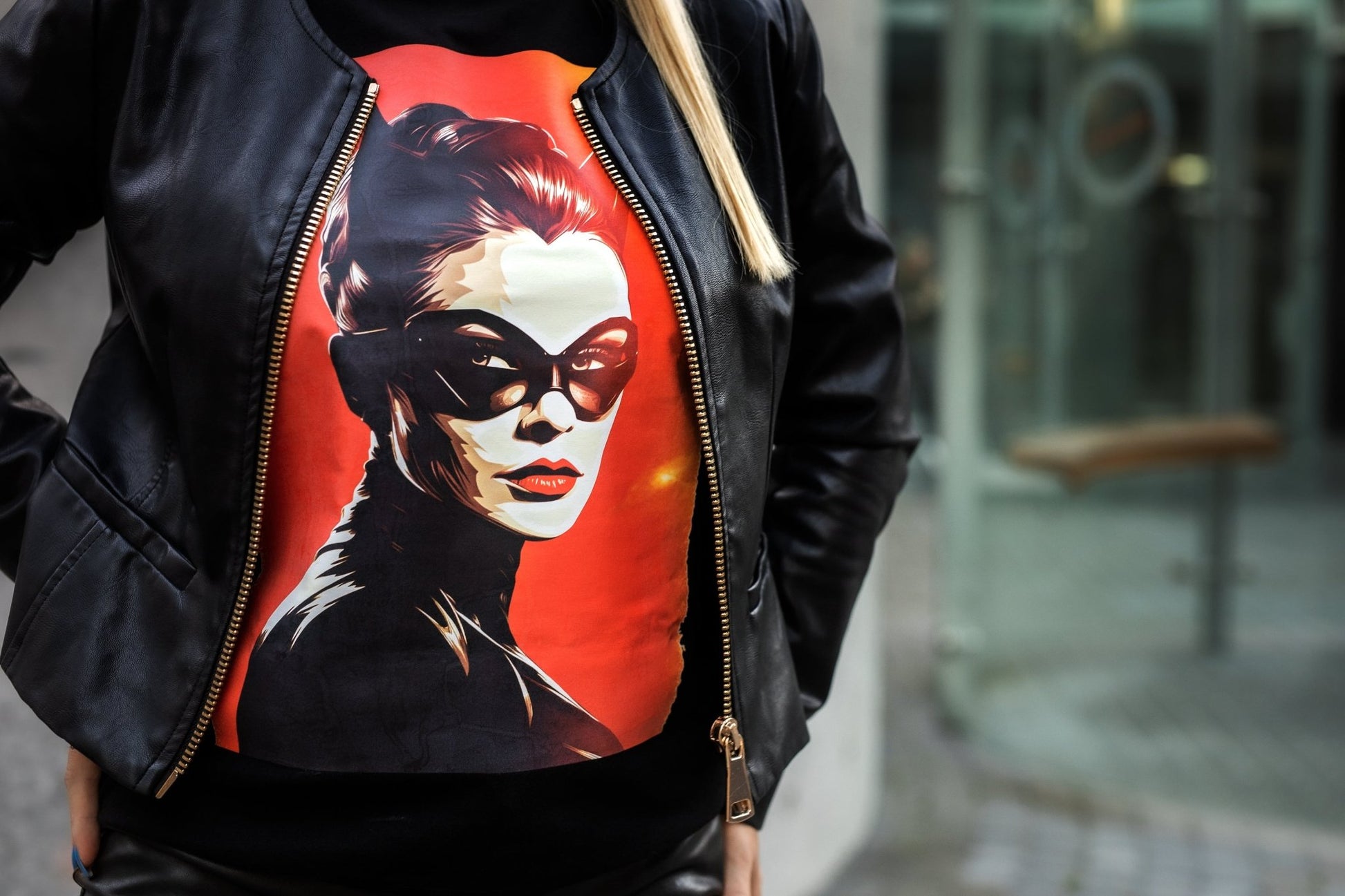 Stilingi moteriški marškinėliai su Catwoman atvaizdu, ryškiomis spalvomis ant raudono fono. Marškinėliai dėvimi po juoda odinė striuke, atspindintys modernų ir drąsų stilių. Puikus pasirinkimas Designedbyme.lt gerbėjoms, Moteriški marškinėliai, Naujausi dizainai