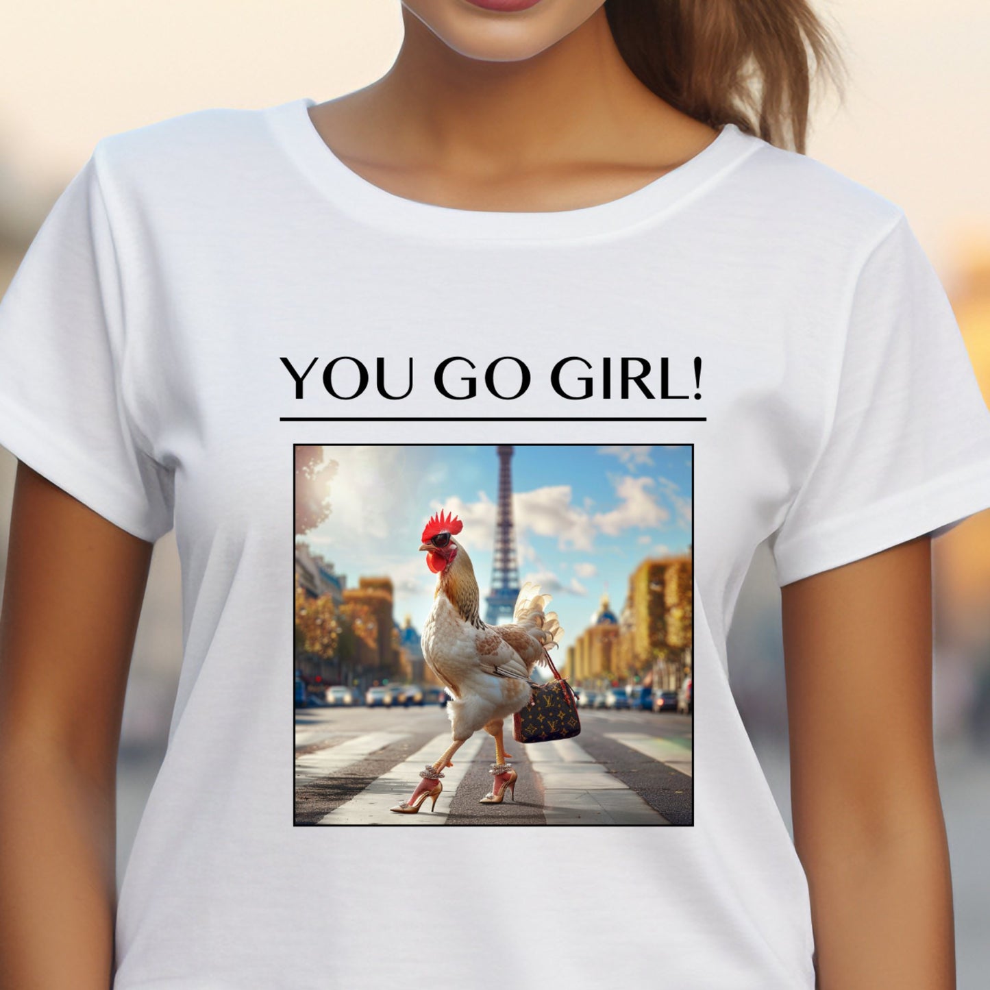 Stilingi balti moteriški marškinėliai su linksmu paveiksliuku, vaizduojančiu vištą aukštakulniais bateliais miesto gatvėje. Unikalus dizainas su užrašu "You Go Girl!". Puiki dovana draugei ar sau. Designedbyme.lt originalus kūrinys, Moteriški marškinėliai, Vasaros kolekcija, Naujausi dizainai